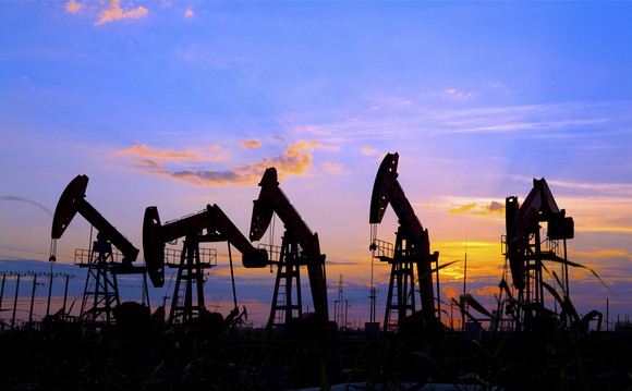 Several oil pumps in a row at dusk.