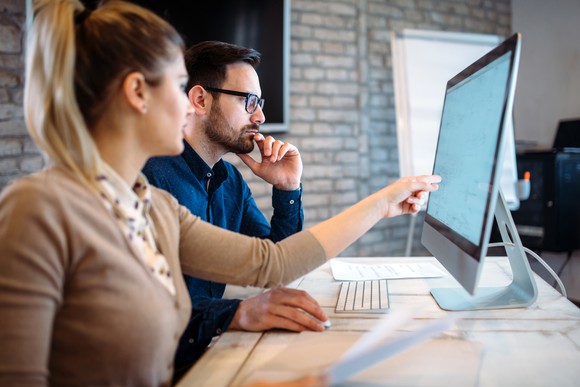 Man and woman working at a computer.