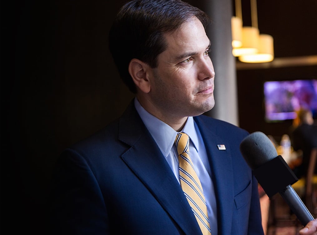 Marco Rubio at a podium with a microphone.