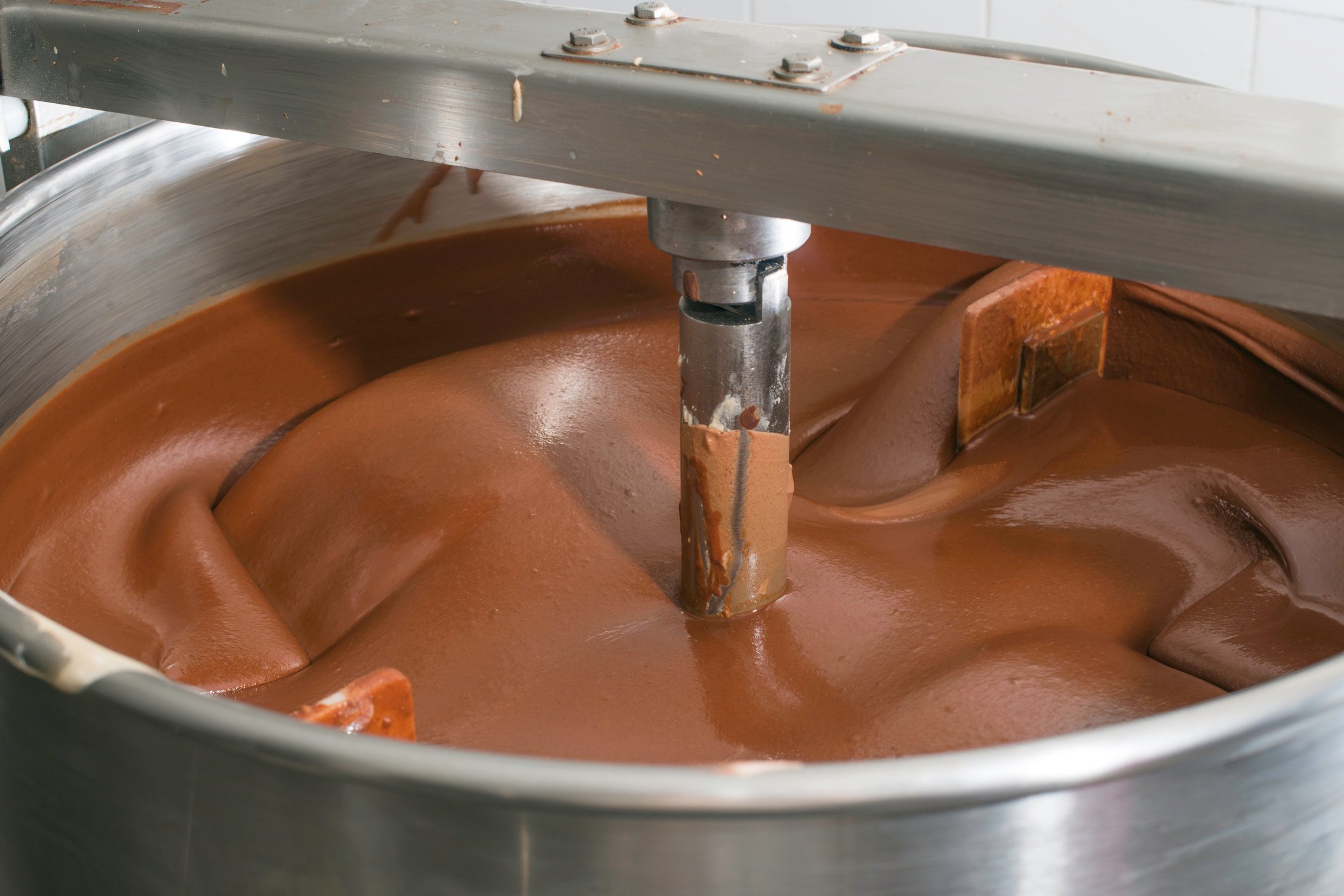 A factory machine churning chocolate.