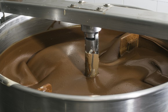 A factory machine churning chocolate.