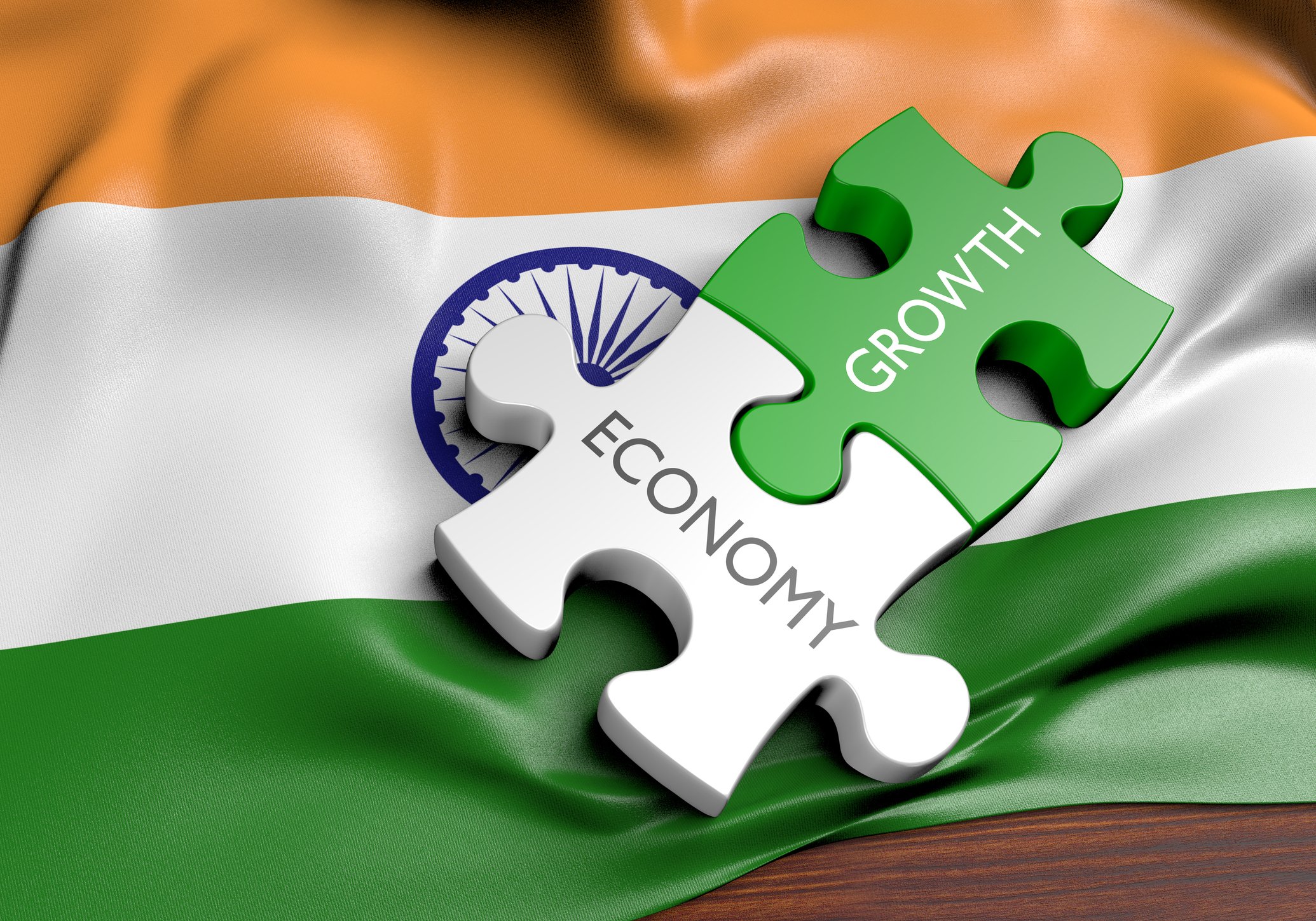 Two jigsaw pieces with economy and growth written on each against a backdrop of the Indian flag.