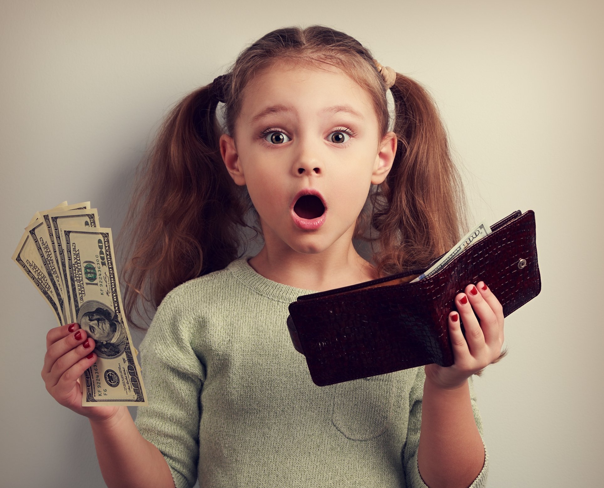 Girl holding wallet and $100 dollar bills