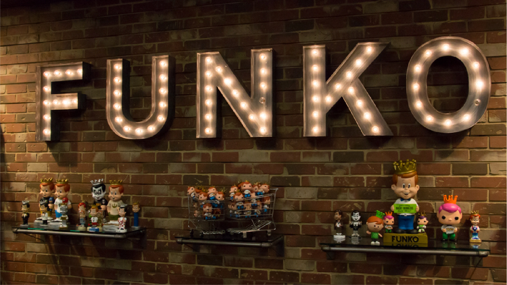 Funko figures on display with a lit FUNKO sign above them.