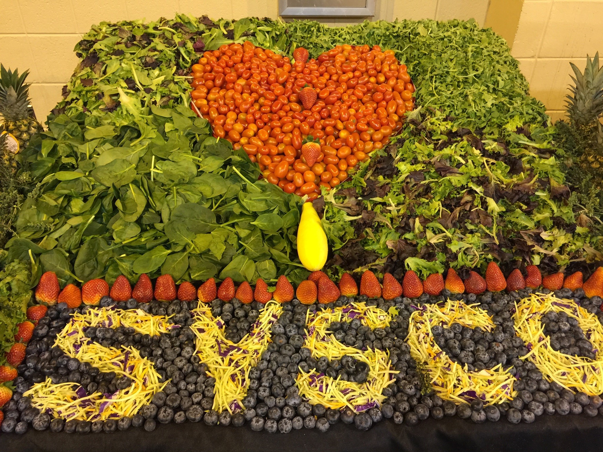 Display spelling Sysco out of greens, fruits, and vegetables.