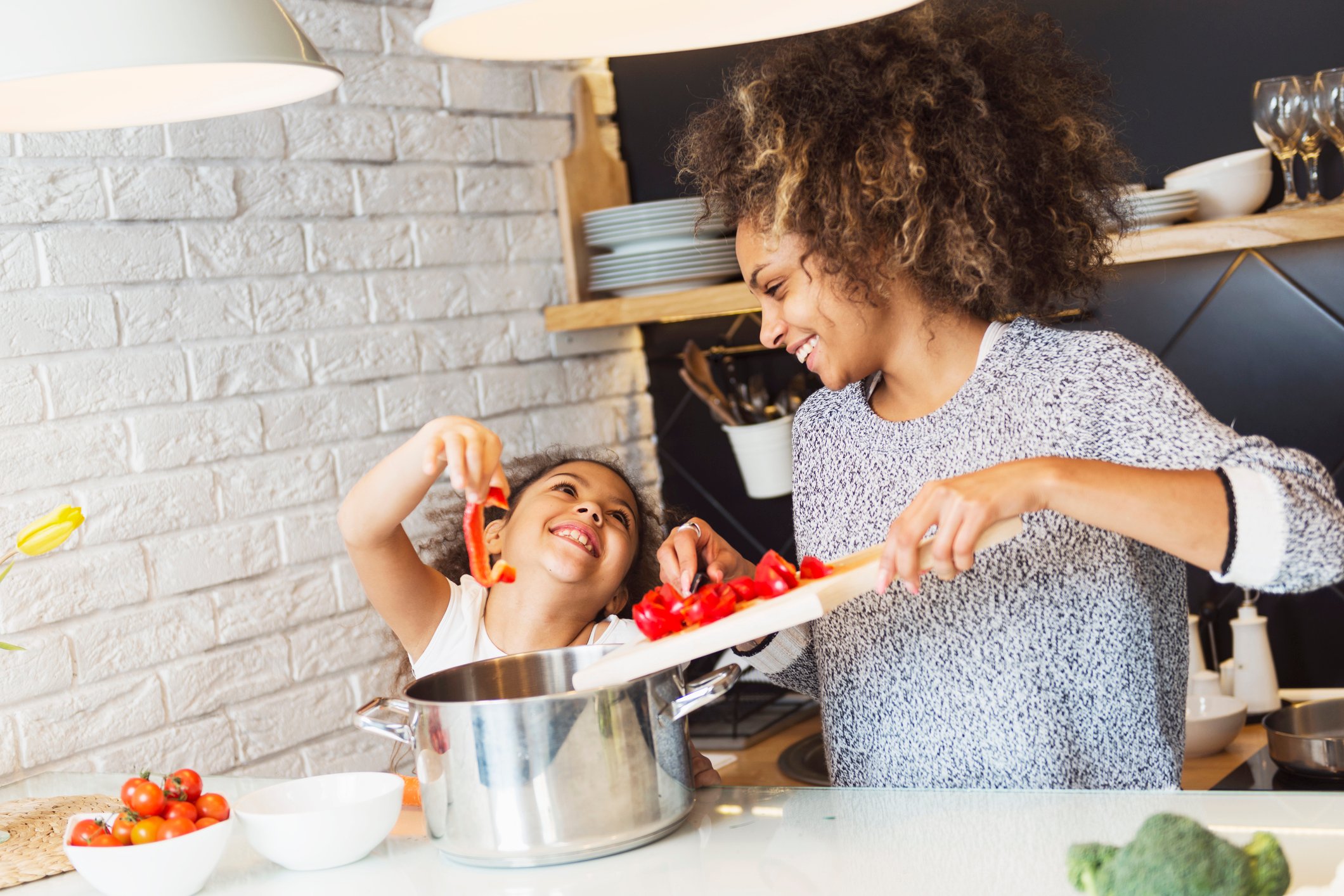 A woman and child cooking in a kitchen.