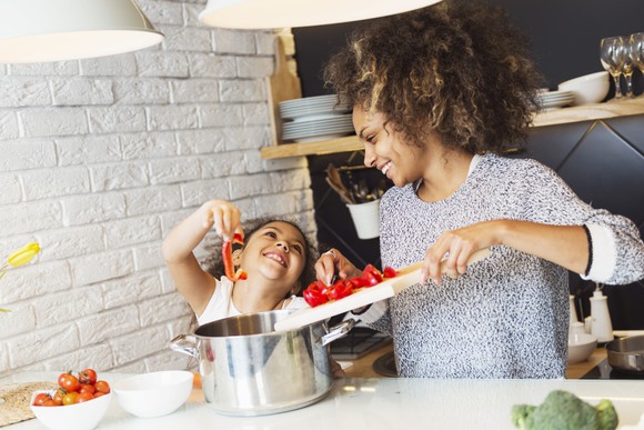 A woman and child cooking in a kitchen.
