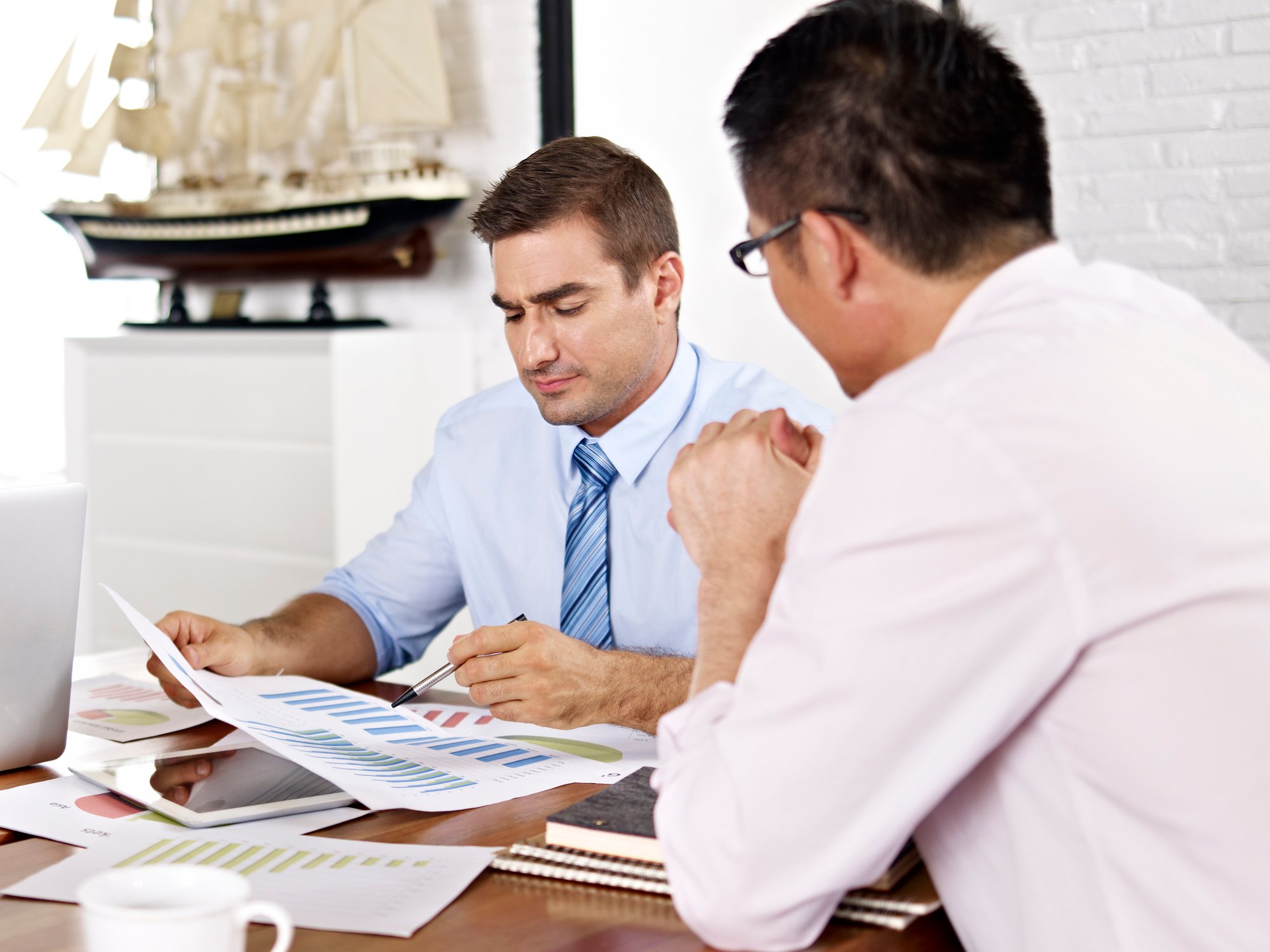 Two professionals reviewing paperwork at a desk