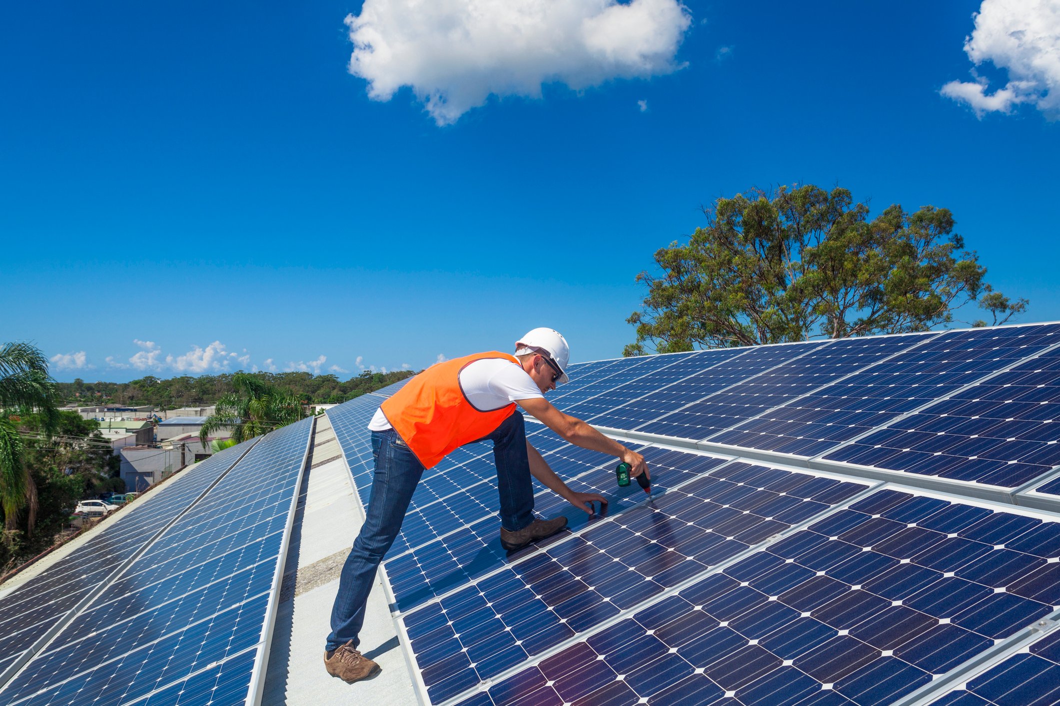 A worker installing rooftop solar panels.