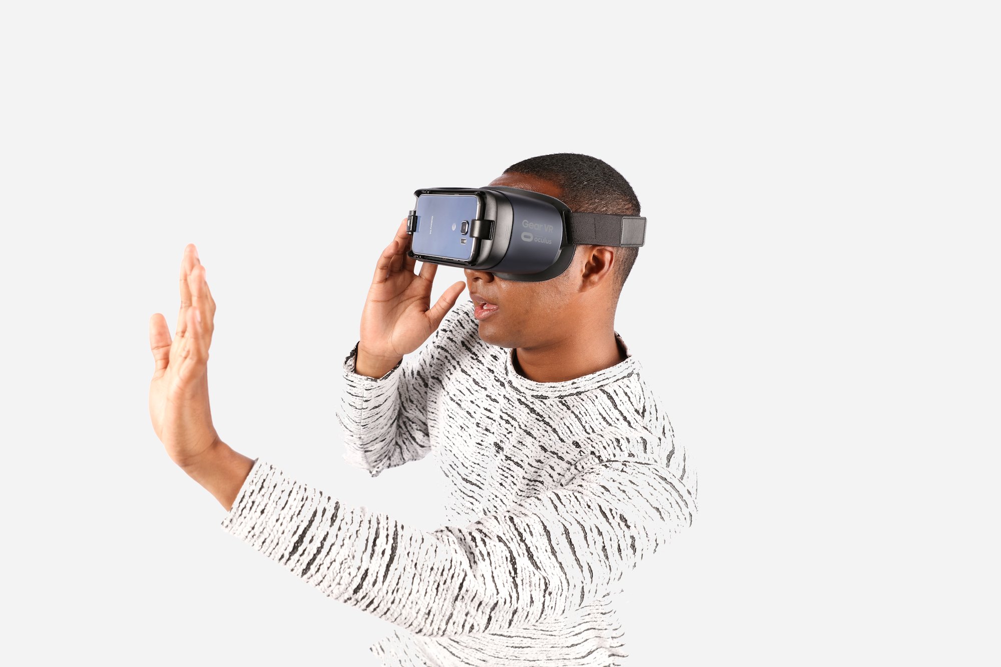 Man wearing Gear VR on his head and holding his hand out