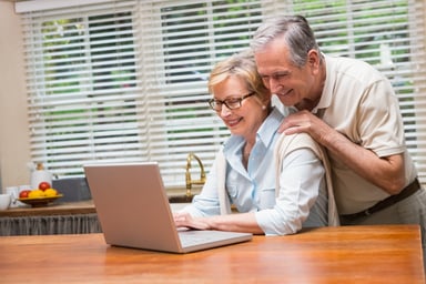 Couple in their 60s looking at PC