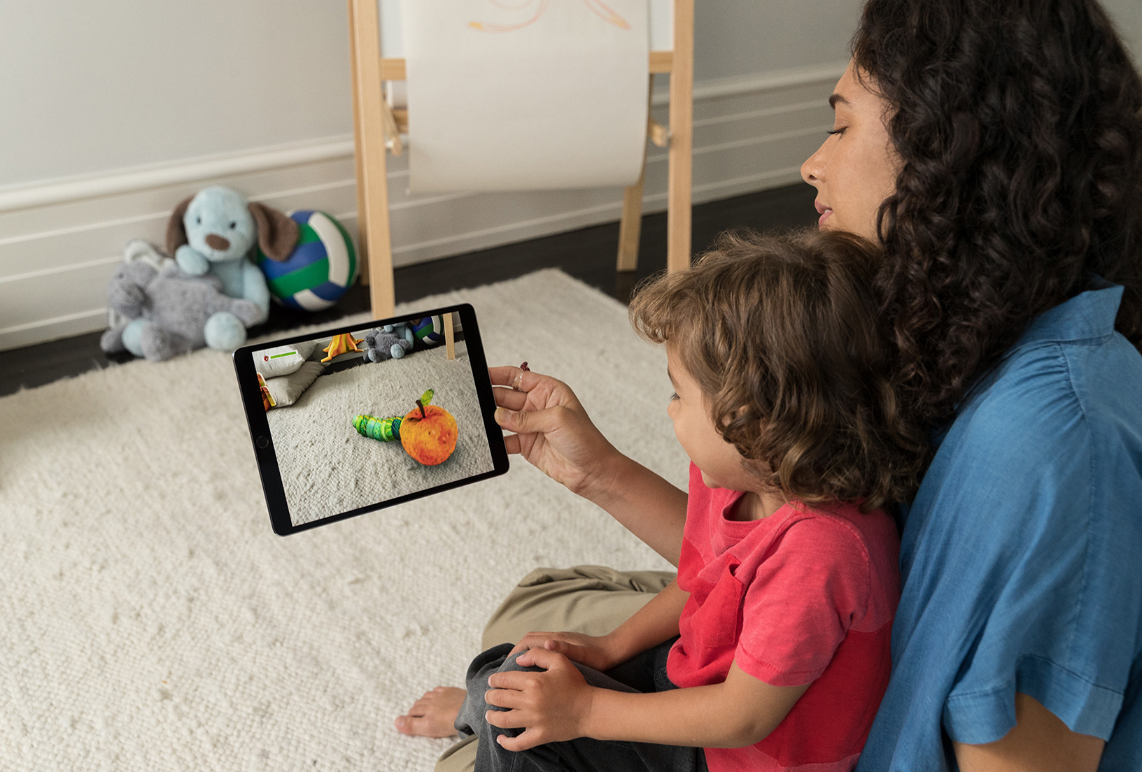 Woman holding iPad with child in her lap.