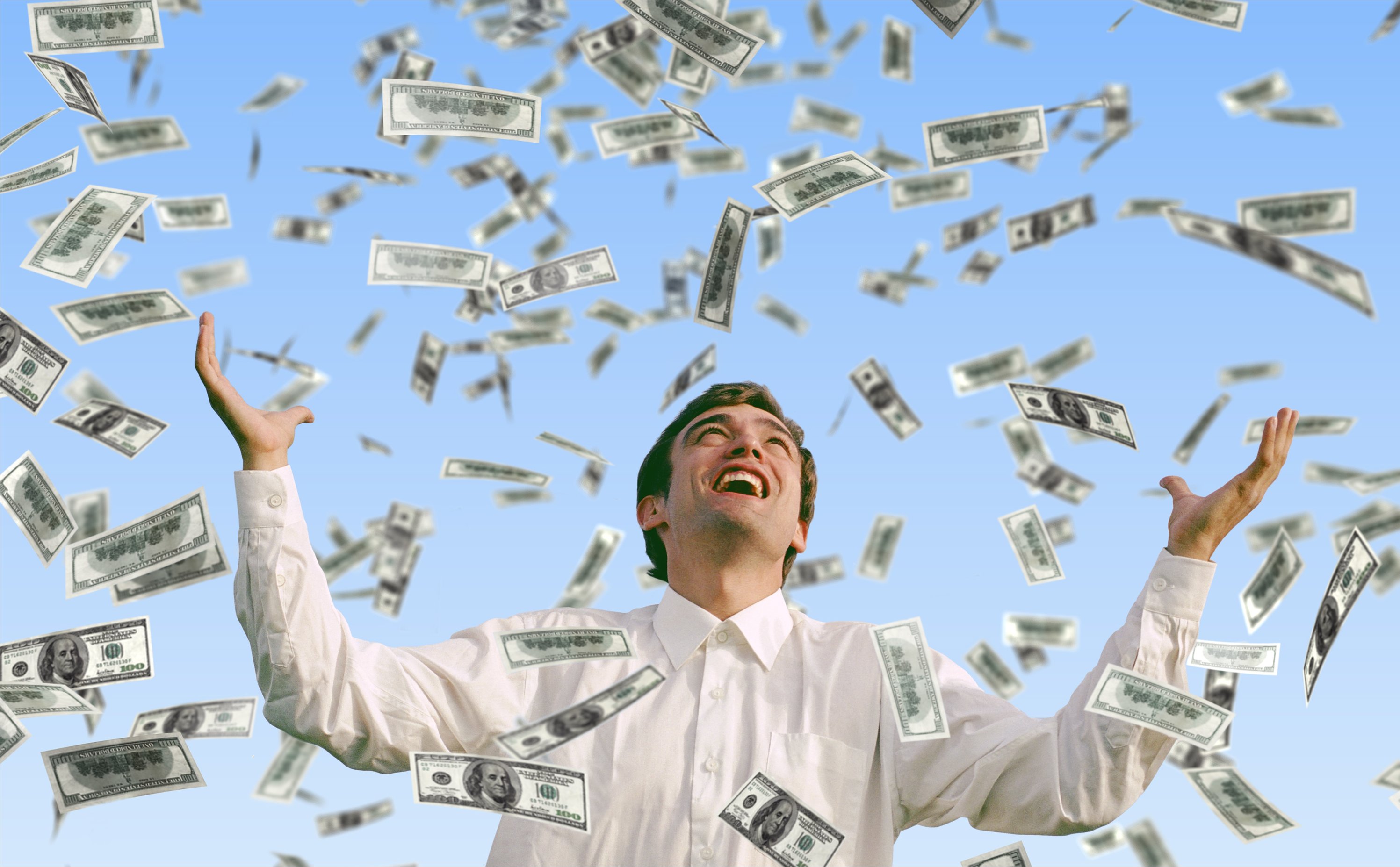 A man stands in a shower of cash.