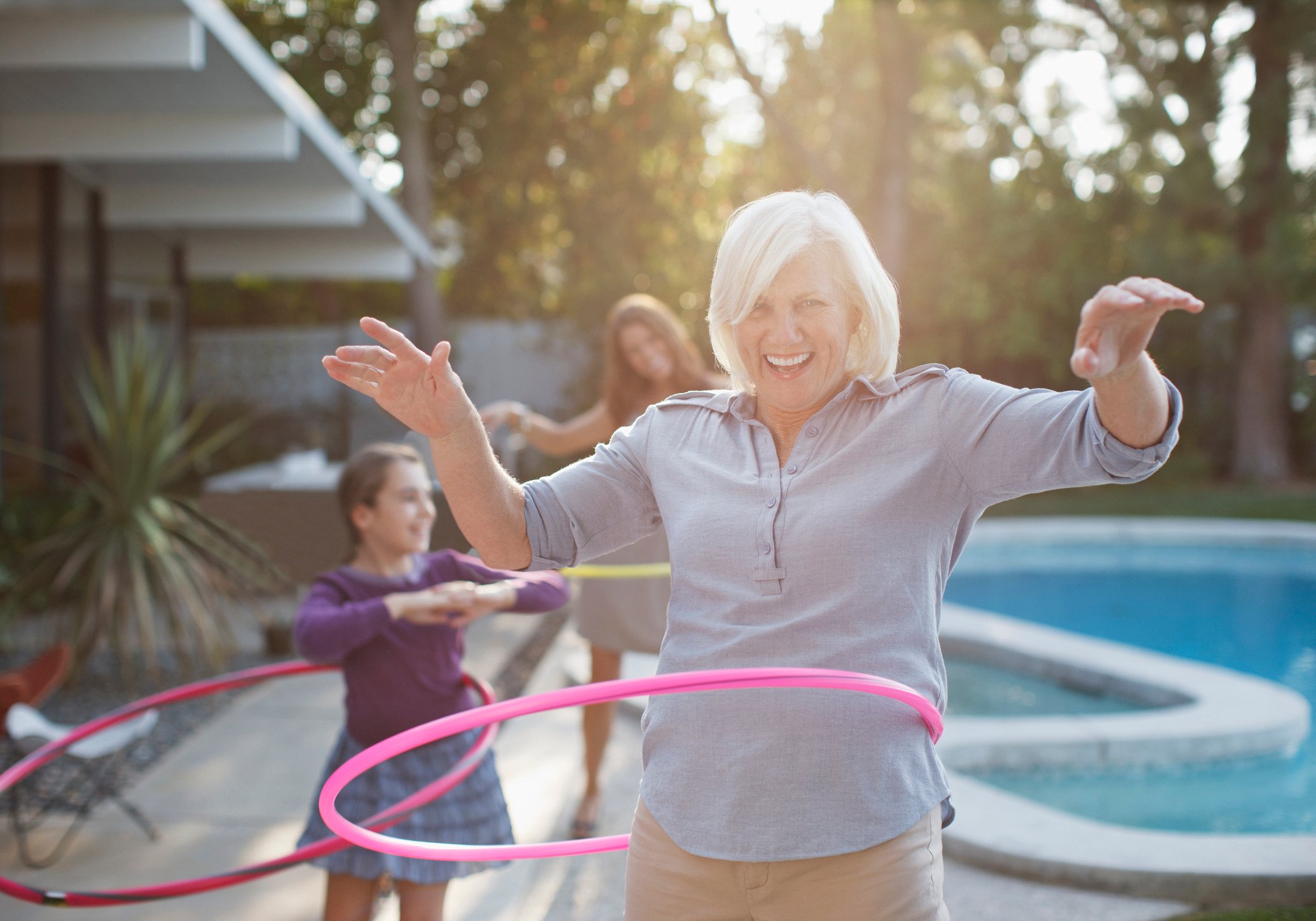Older woman hoola-hooping with grandchildren