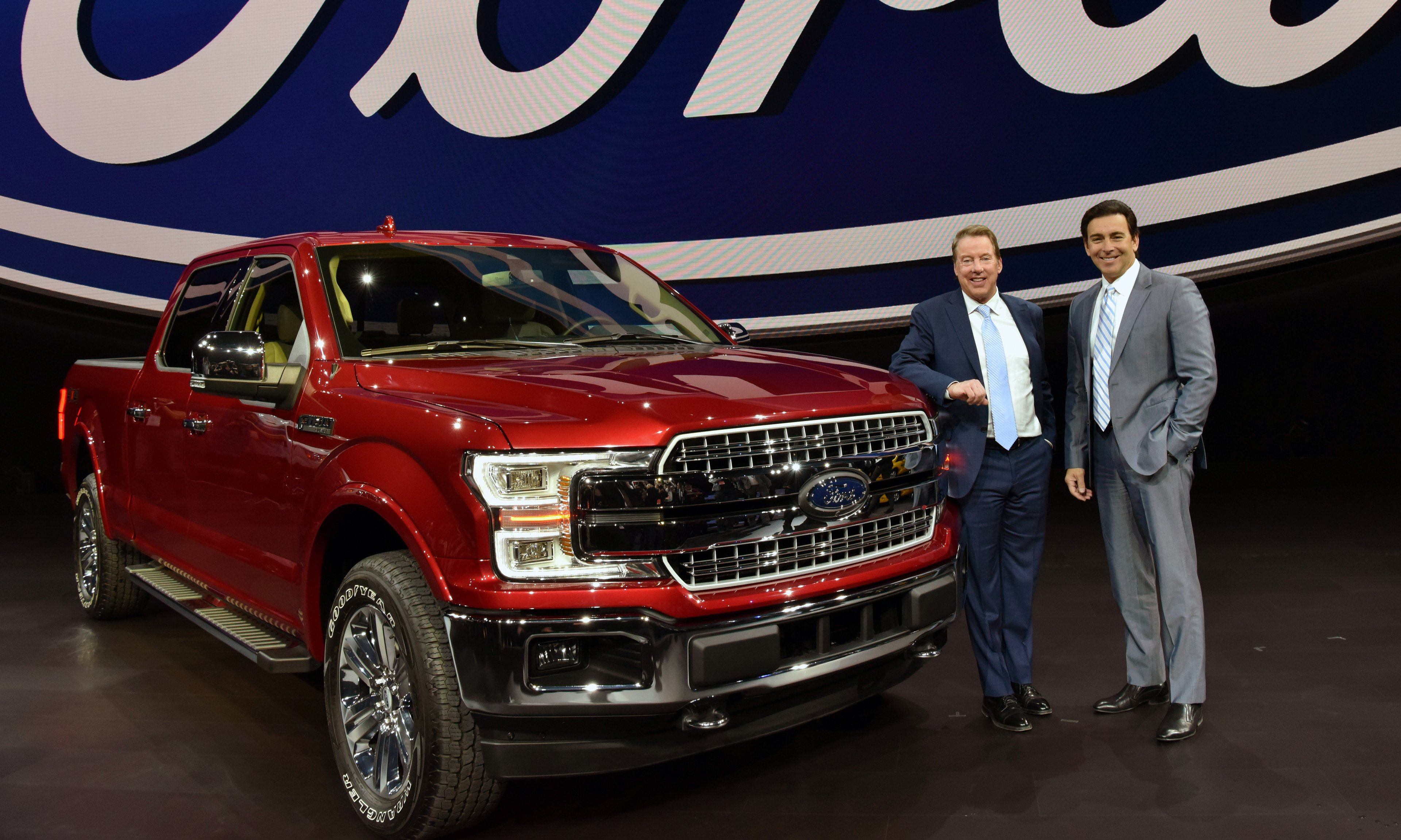 Bill Ford and Mark Fields are shown standing next to a red 2018 Ford F-150 pickup.