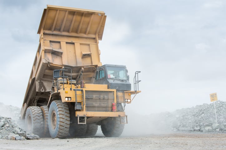 A giant earth mover truck leaving a mine.