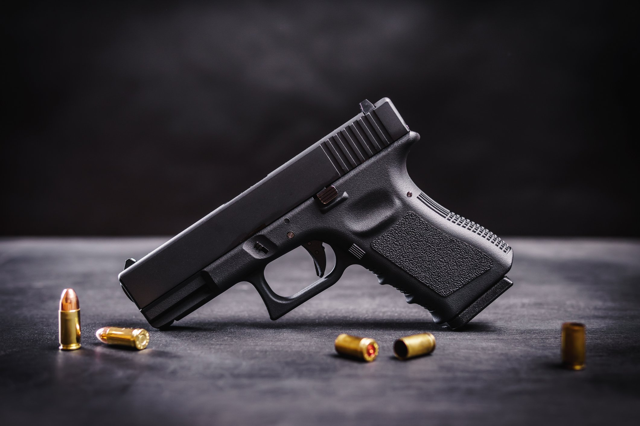 Handgun on a table with assortment of bullets. 