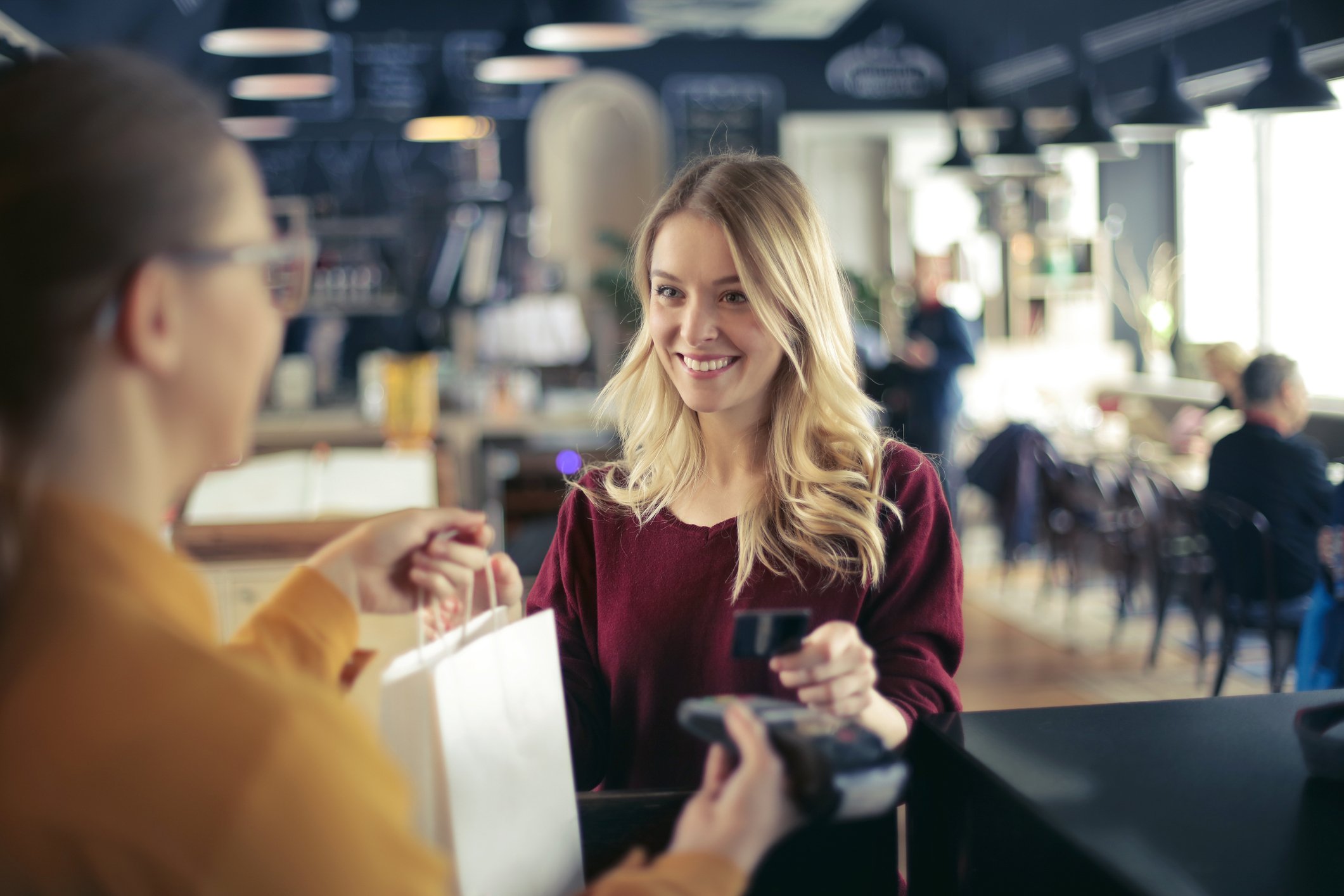 A woman at checkout counter paying with a credit card