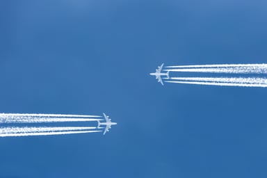 two planes flying toward each other jet trail