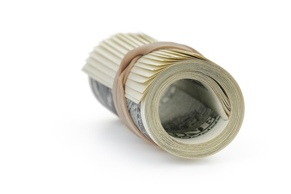 A roll of U.S. currency held together with a rubber band.