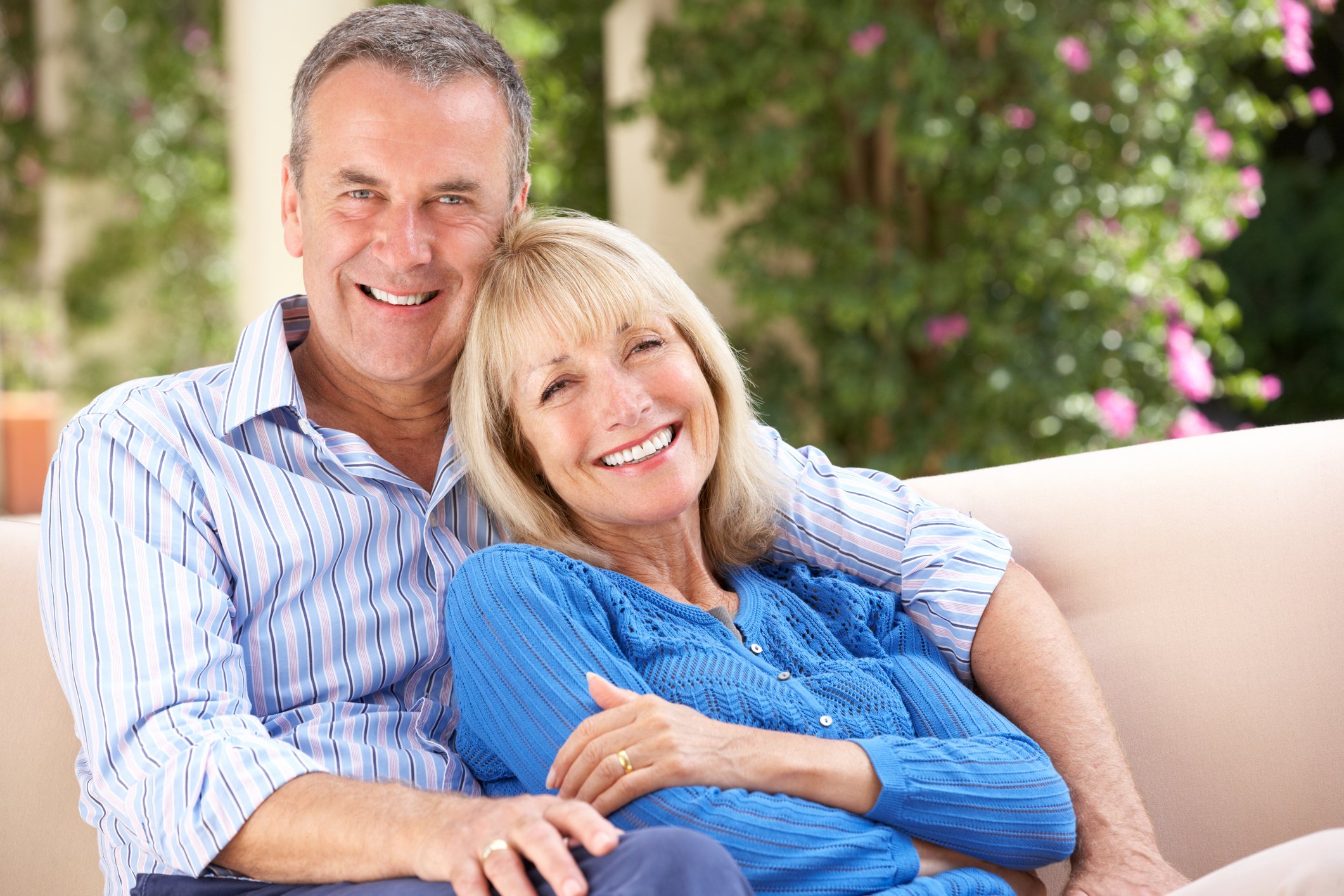 Smiling older couple sitting on a couch