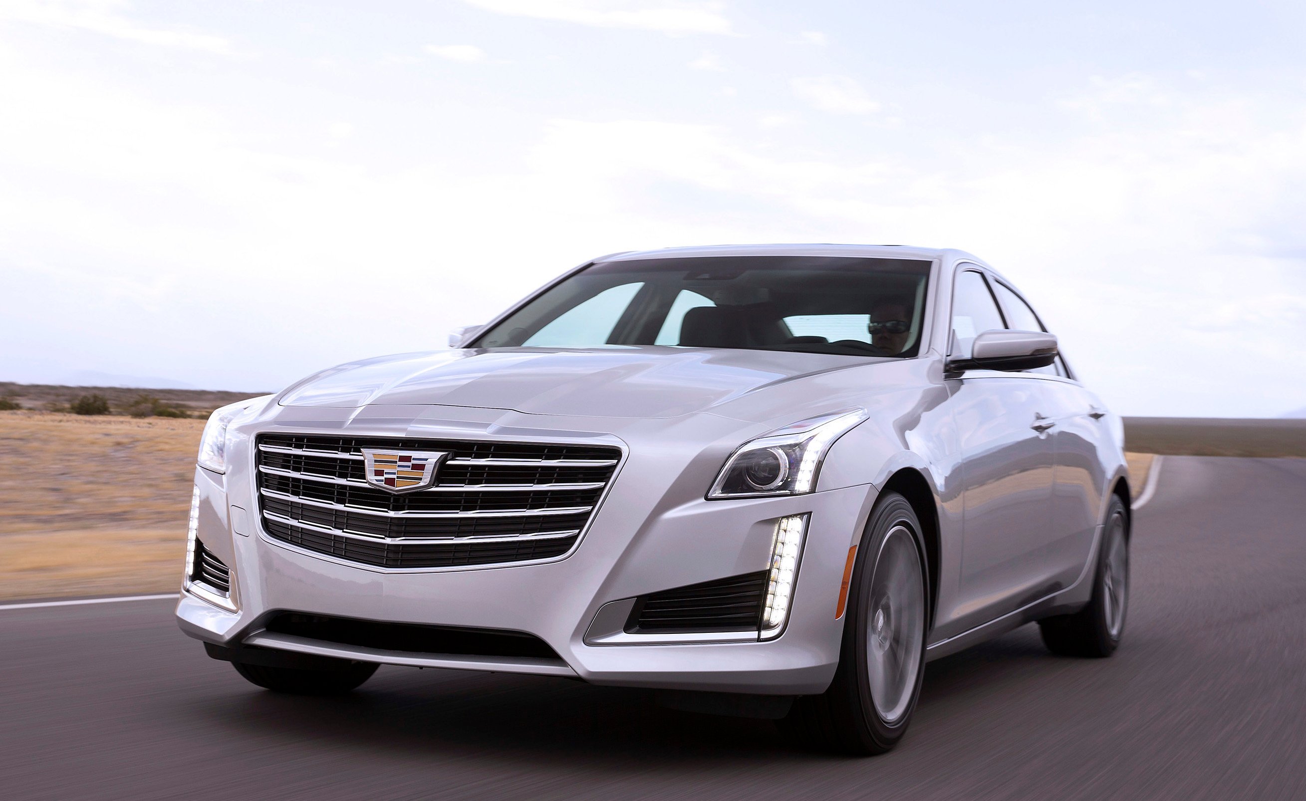 A silver Cadillac CTS luxury sedan on a country road.