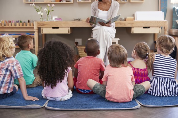 Group of young children sitting on classroom floor.