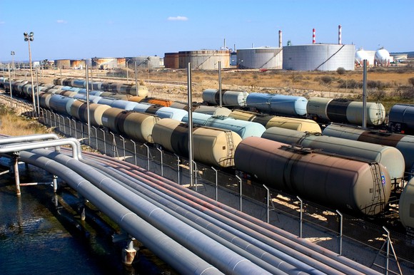 Crude oil logistics featuring tankers, railcars, and a pipeline.