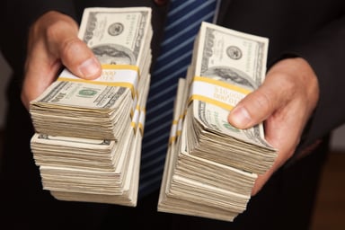 Businessman With Stacks of Money Cash Getty