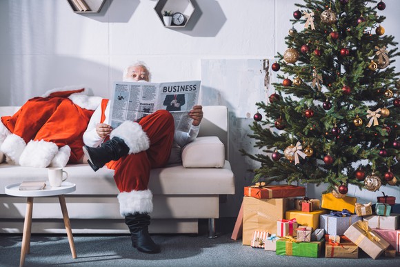 Santa reading the business section of the newspaper