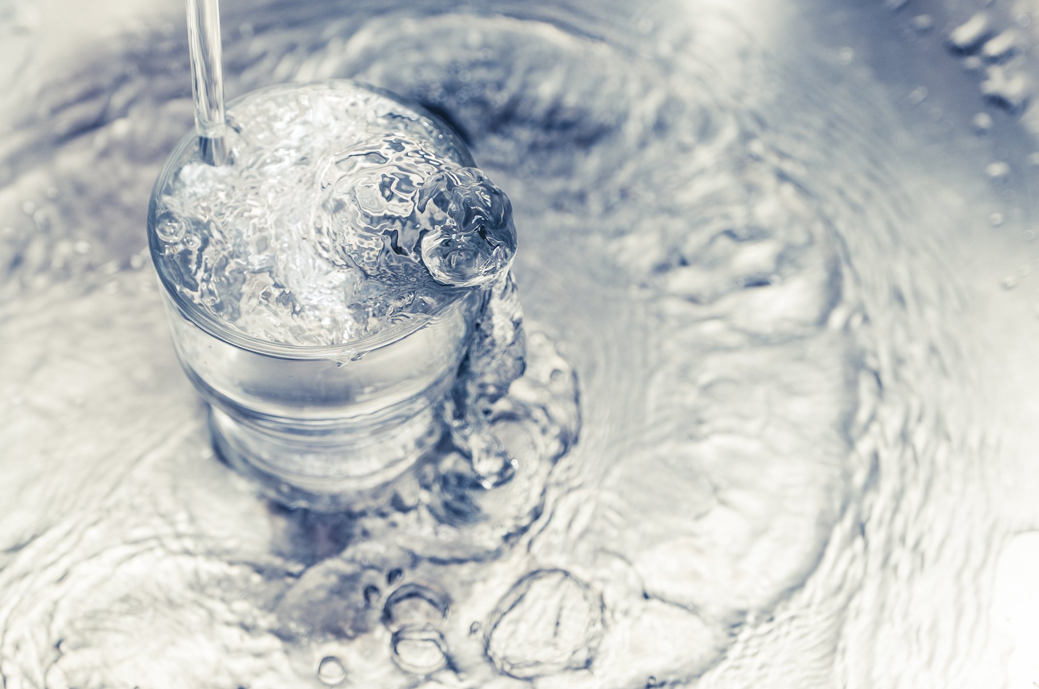 Water pouring from a tap into a glass.