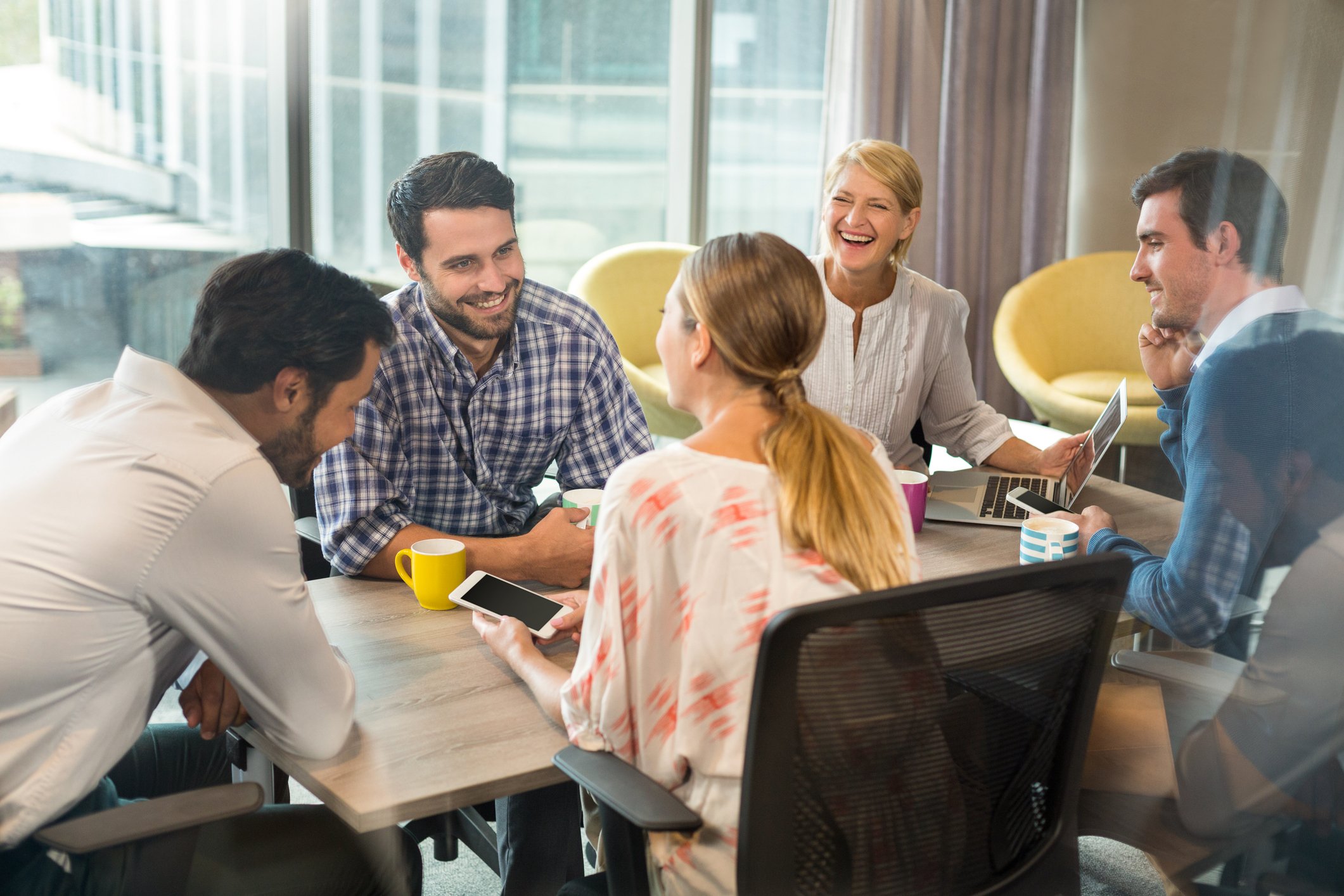 Smiling professionals gathered around a table