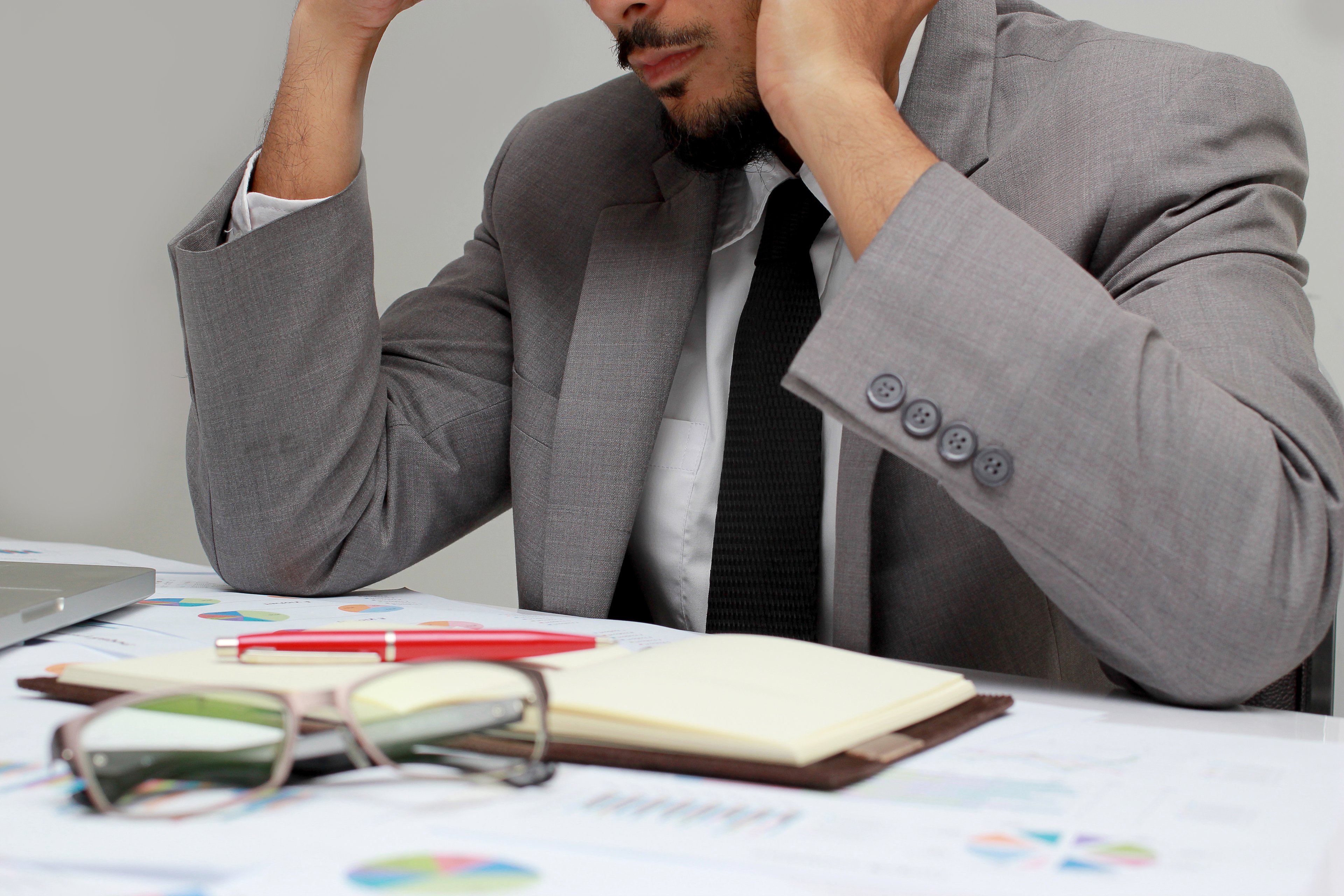 Frustrated man in business attire looking at an open planner