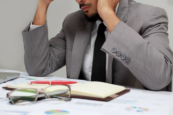 Frustrated man in business attire looking at an open planner
