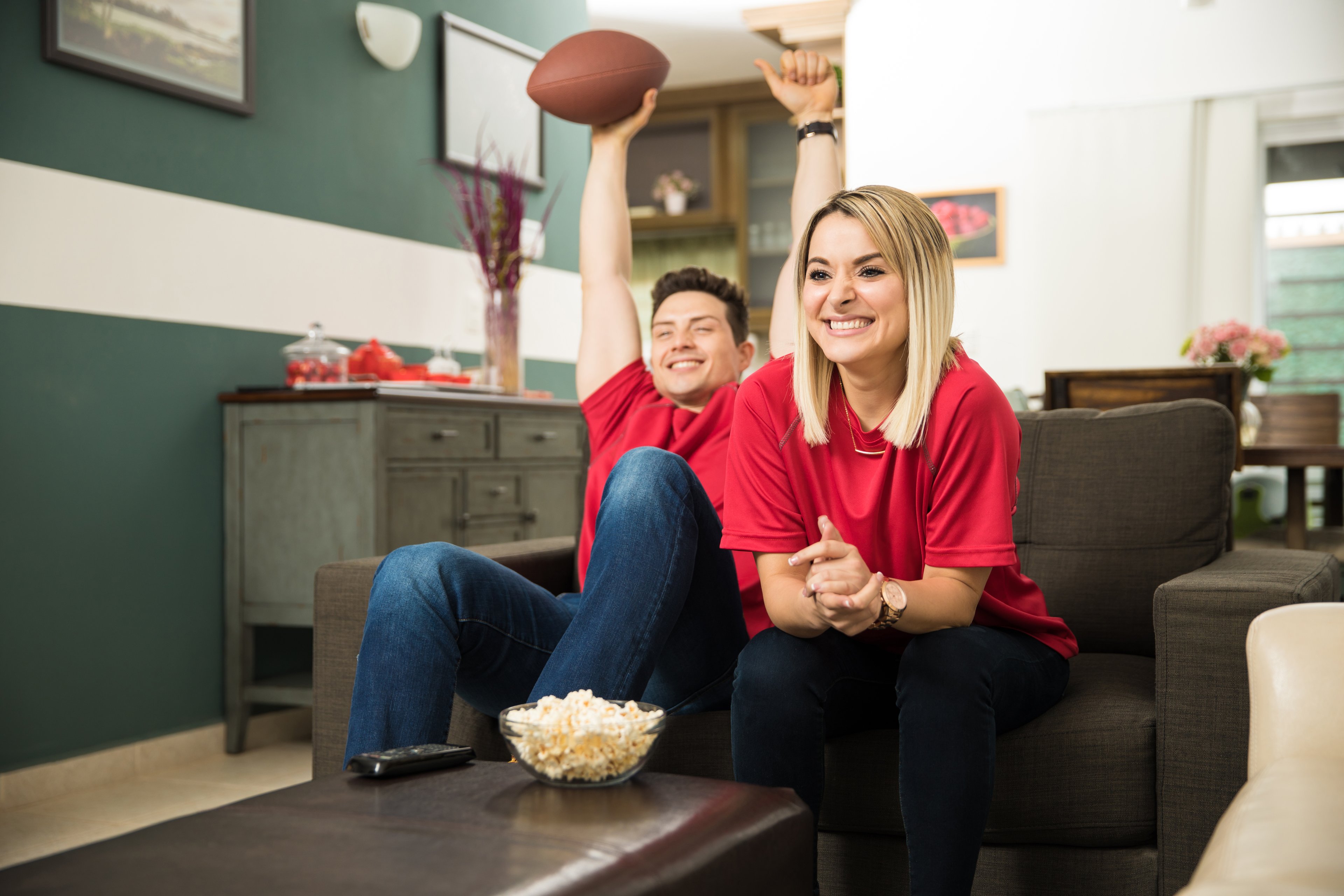 Couple on couch watching a football game.