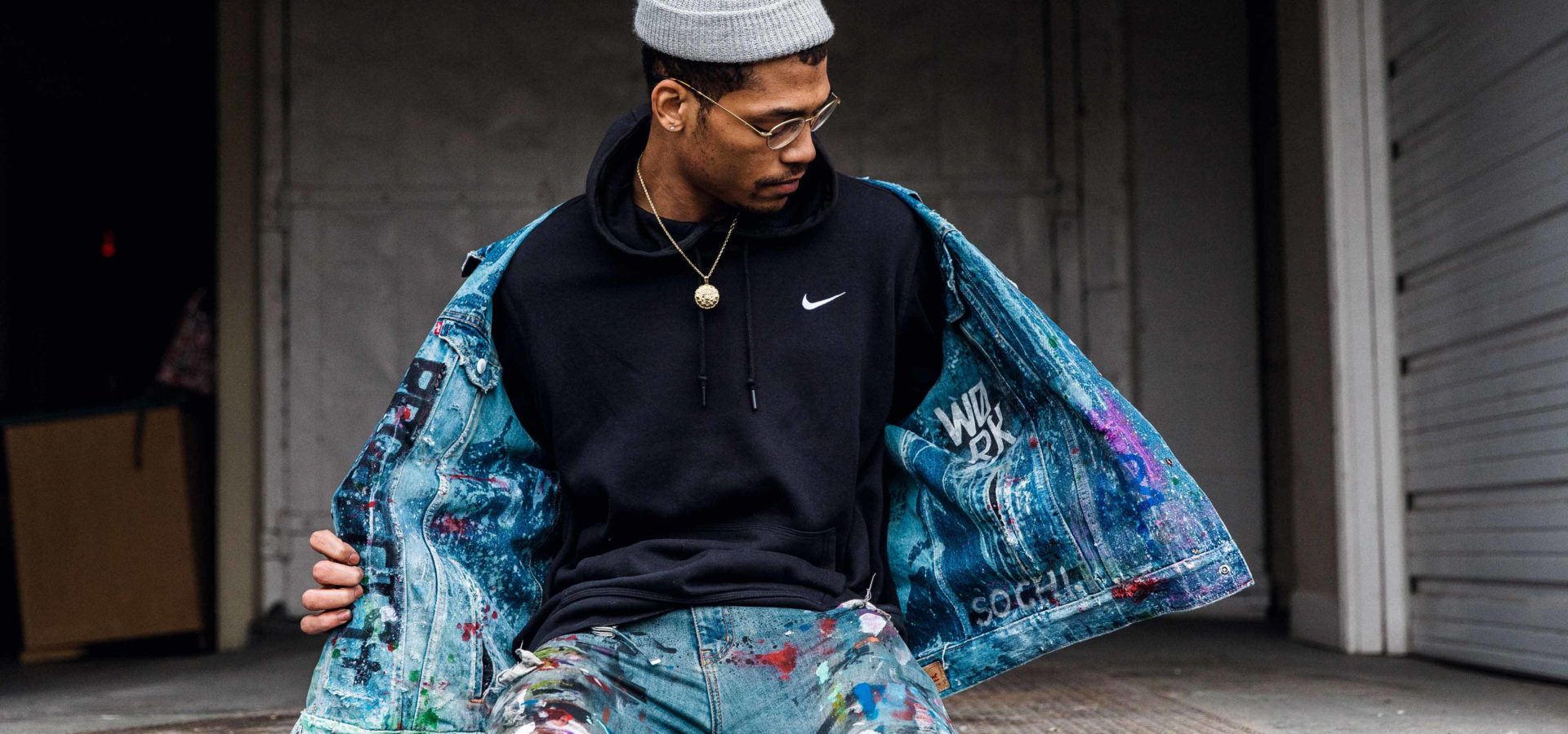 An artist poses in a Nike sweatshirt.