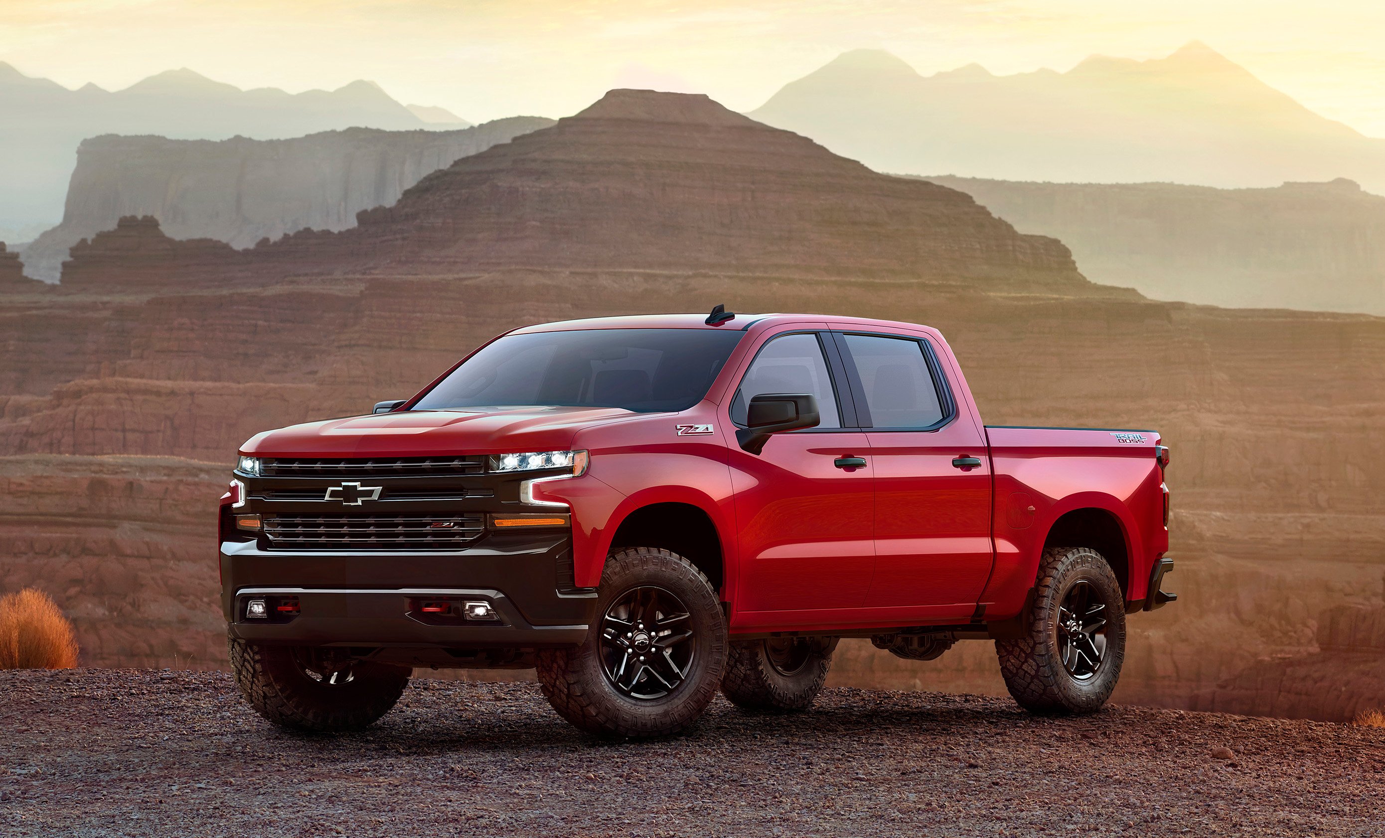 A red 2019 Chevrolet Silverado crew-cab pickup in a desert setting