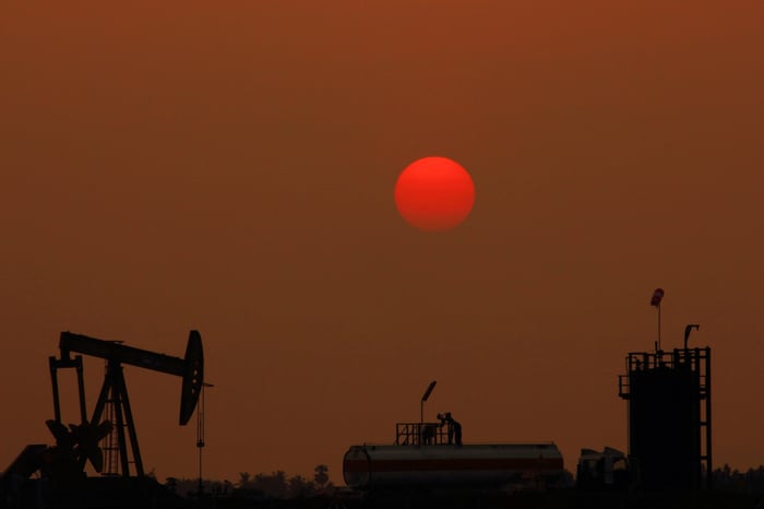 An oil pump with a red moon in the background.