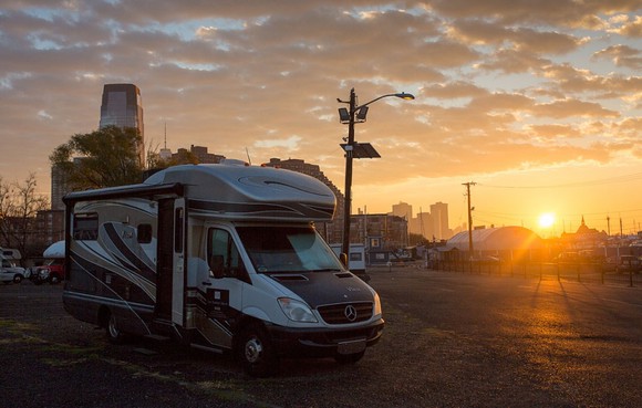 A Winnebago RV parked with a sunset in the background