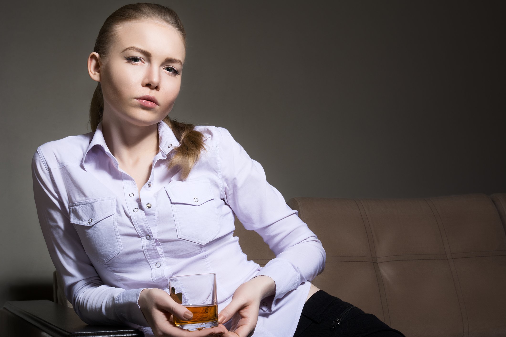Woman holding a glass of whiskey