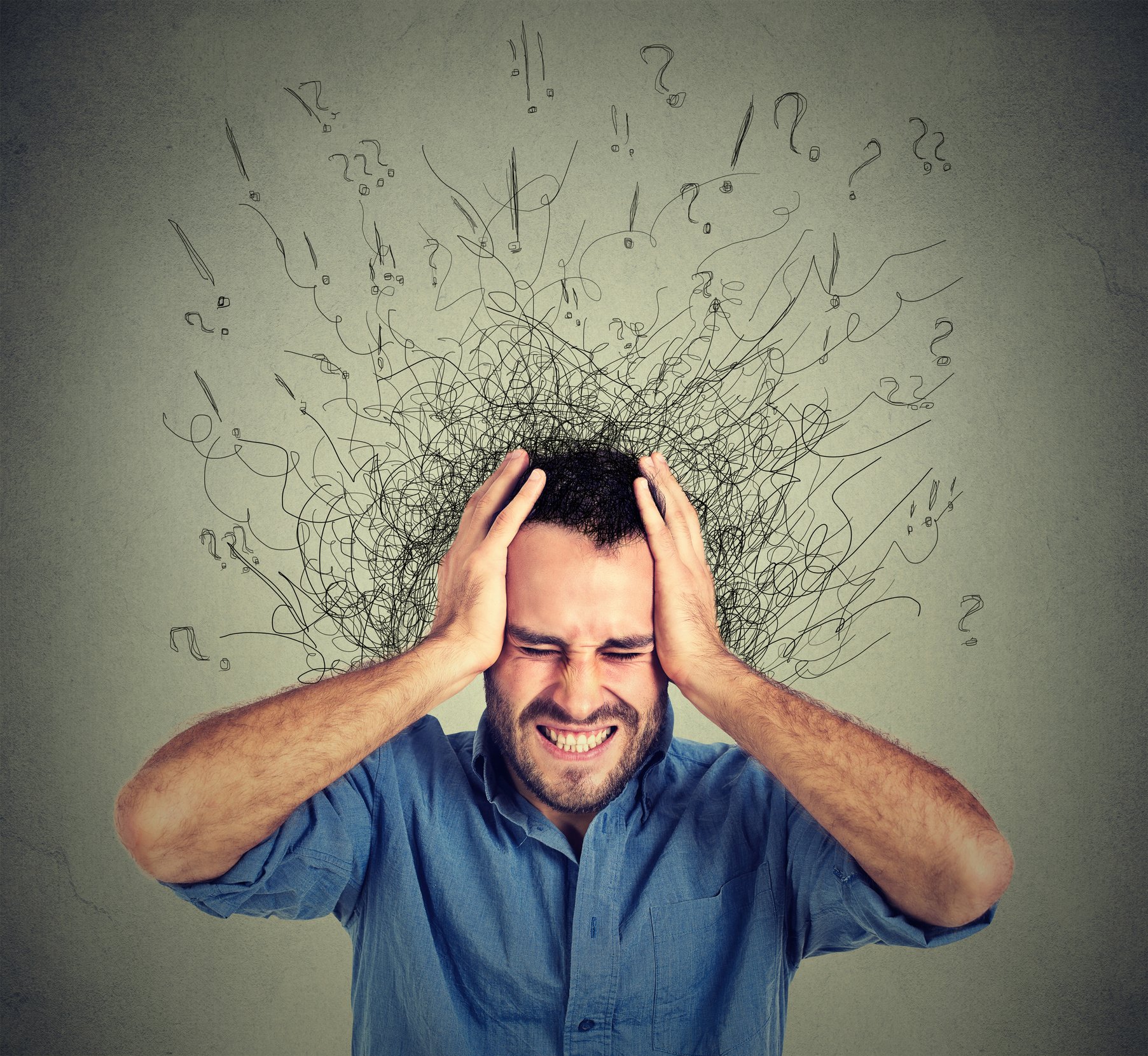 Stressed man upset frustrated has too many thoughts with brain melting into lines question marks.
