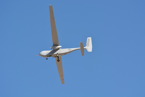 Orion drone in flight against a clear blue sky