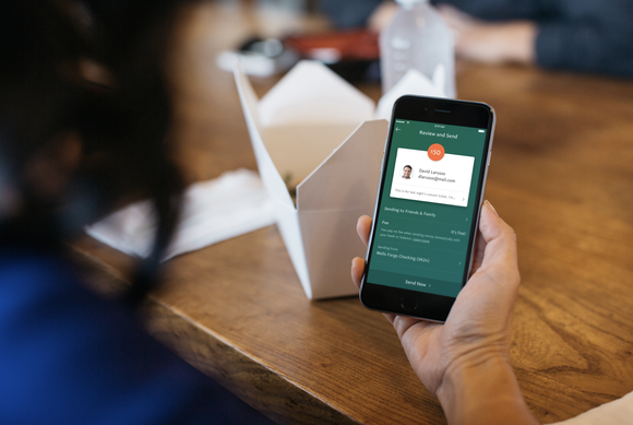 A hand holding smartphone with the PayPal app displayed.