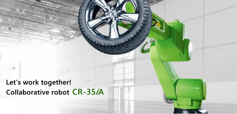 A bright green-colored collaborative robot holding an automobile tire in an empty factory.