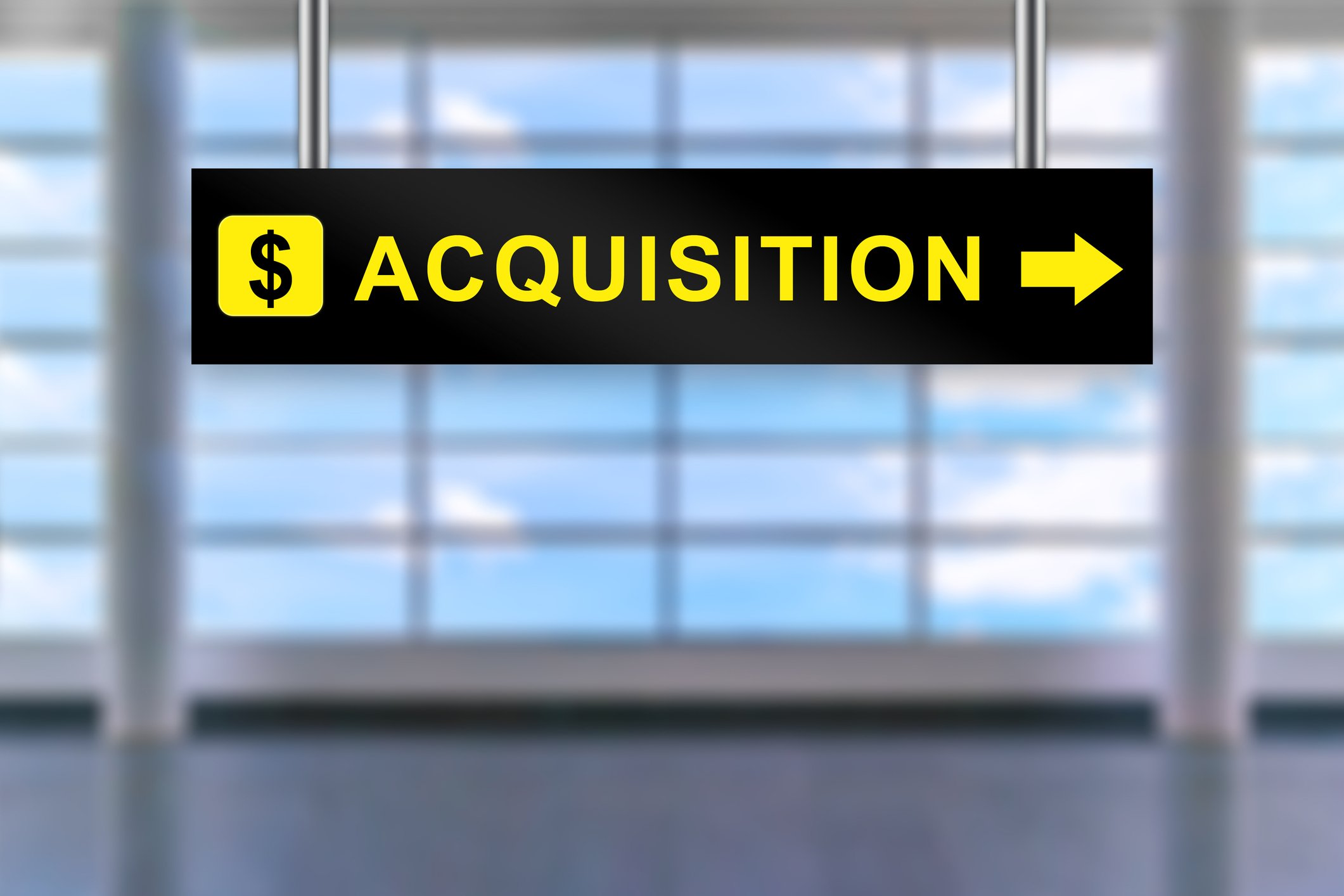 Airport sign with dollar symbol, the word "acquisition", and an arrow pointing right