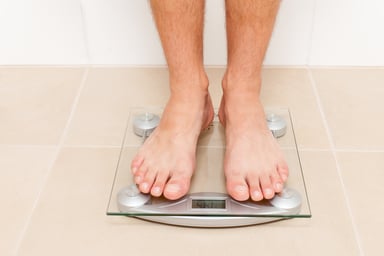 man standing on a scale_GettyImages-599459566
