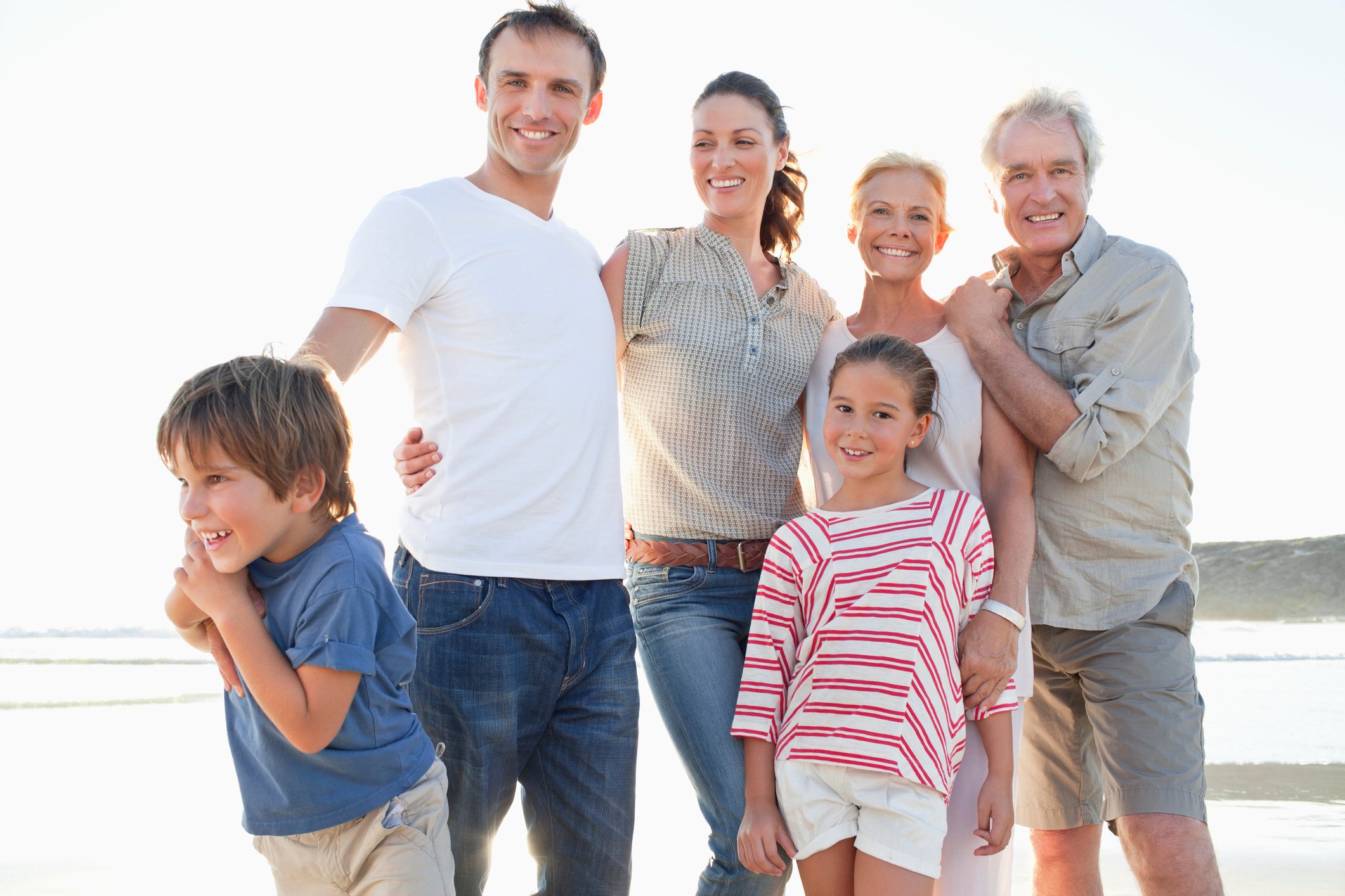 A family of six posing for a picture while on vacation. 