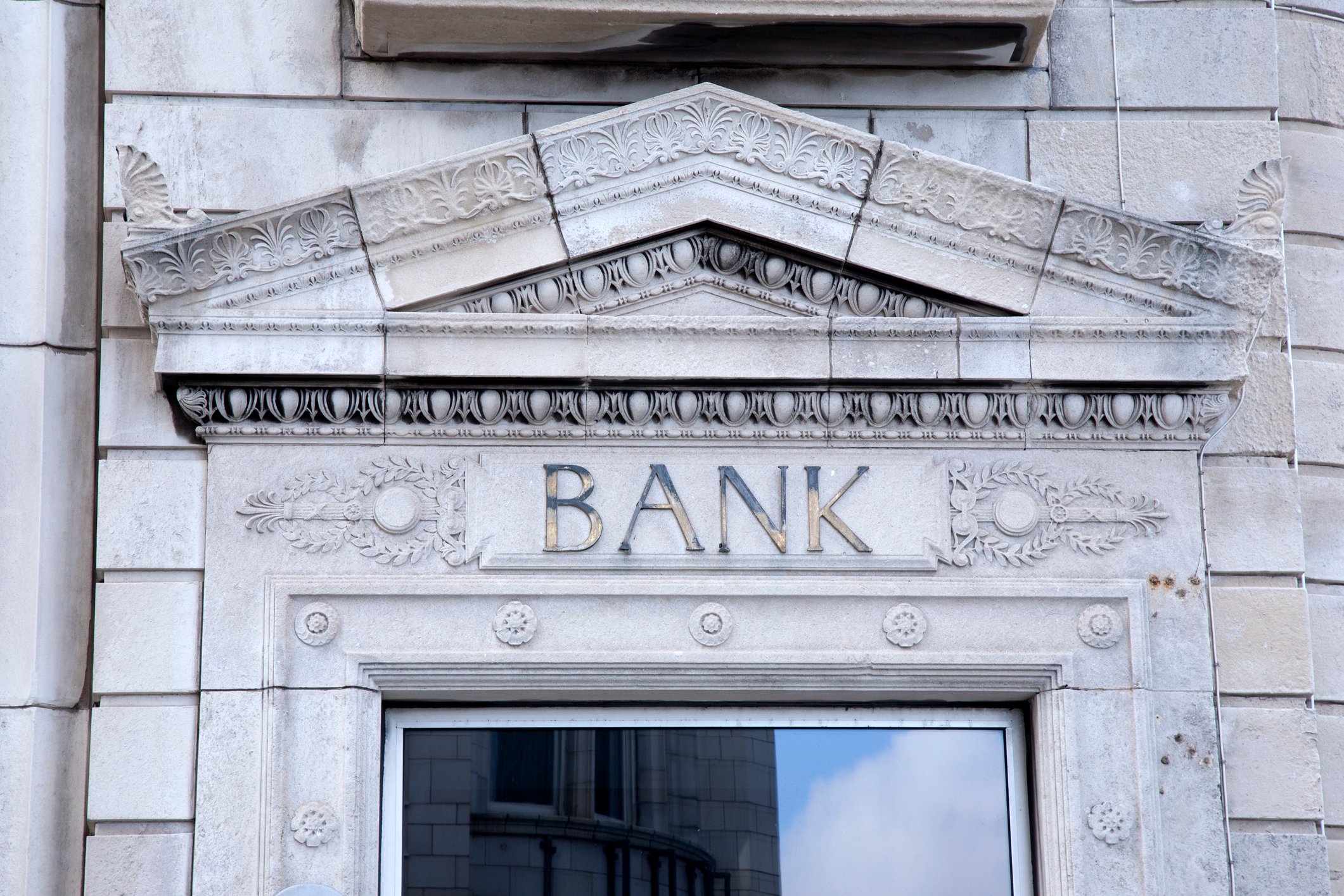 Exterior of a building with BANK over the door.