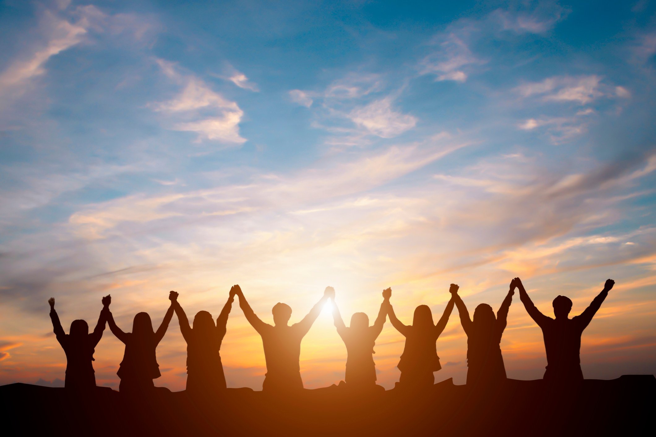 Silhouette of happy business team making high hands in sunset sky background for business teamwork concept