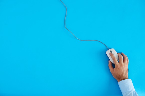 A man's hand on a computer mouse